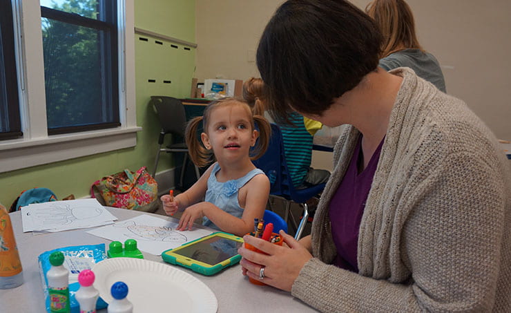 Ruby, one of 3-year-old twins, colors with graduate student Hollie Lawless in July 2015.