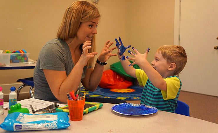 Ian enjoys finger-painting with graduate student Katie Koehler in July 2015.